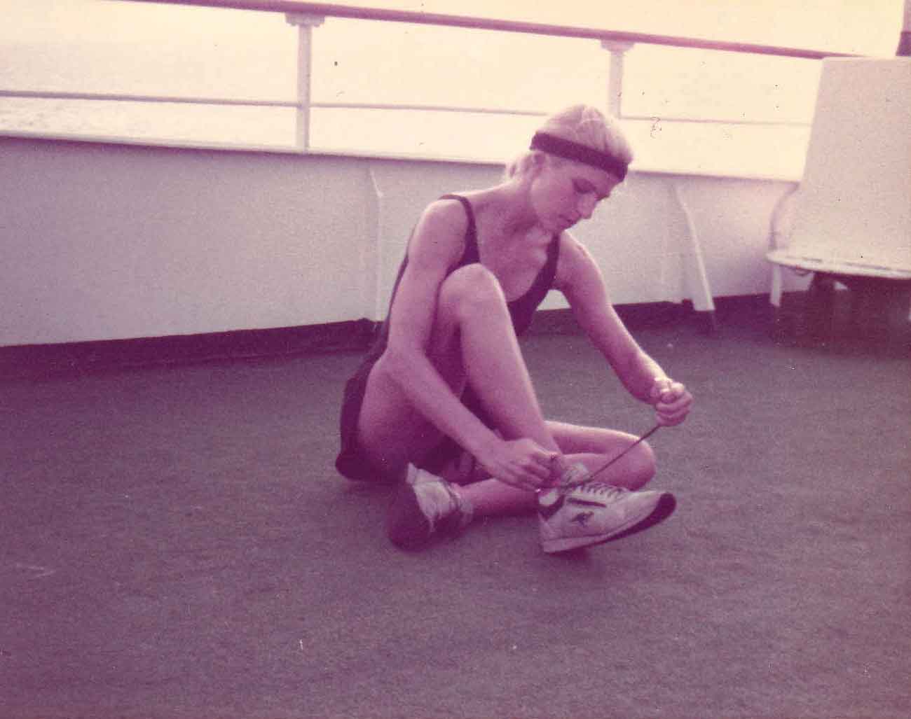 ALT =[“Dr. Jolie Bookspan: Dr. Bookspan pioneered putting fitness on cruise ships in the early 1980s.”Pictured here getting ready to teach Parcours (Parkour, Free Running) starting with a run on the ships rails.] 